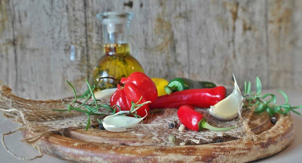 Tahta üzerinde kırmızı biberler, sarımsak ve zeytinyağı